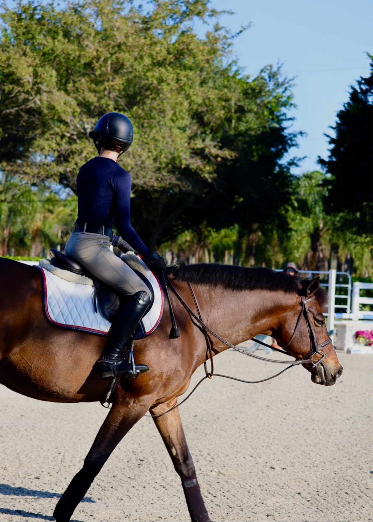 San Eligius white quilted jump saddle pad with red and navy crocodile piping, detail of logo emblem