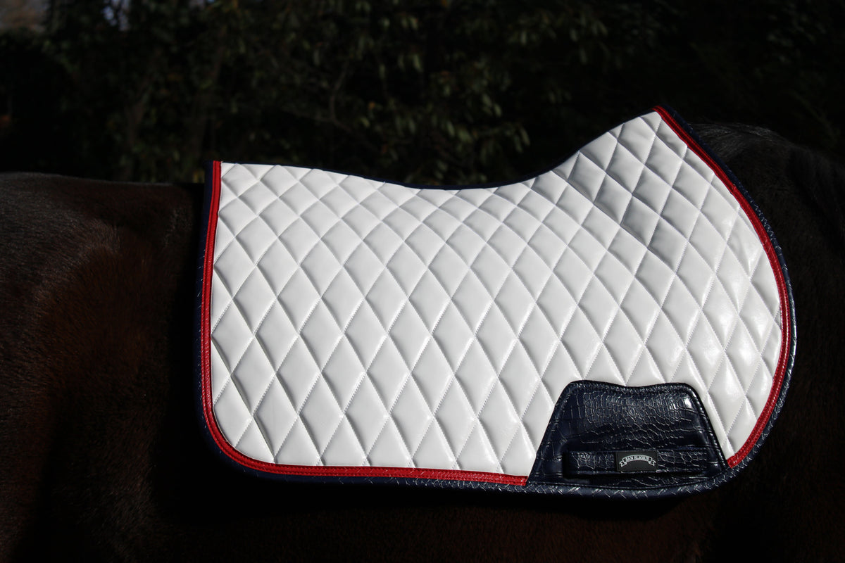San Eligius white quilted jump saddle pad with red and navy crocodile piping, close-up of piping detail