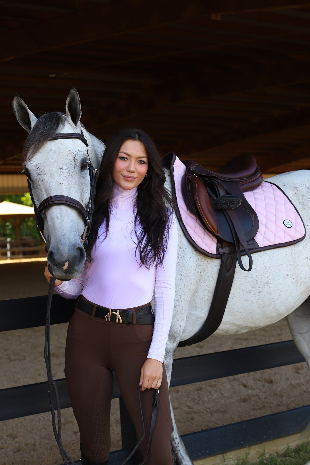 San Eligius pink quilted jump saddle pad with brown leather piping, side profile view