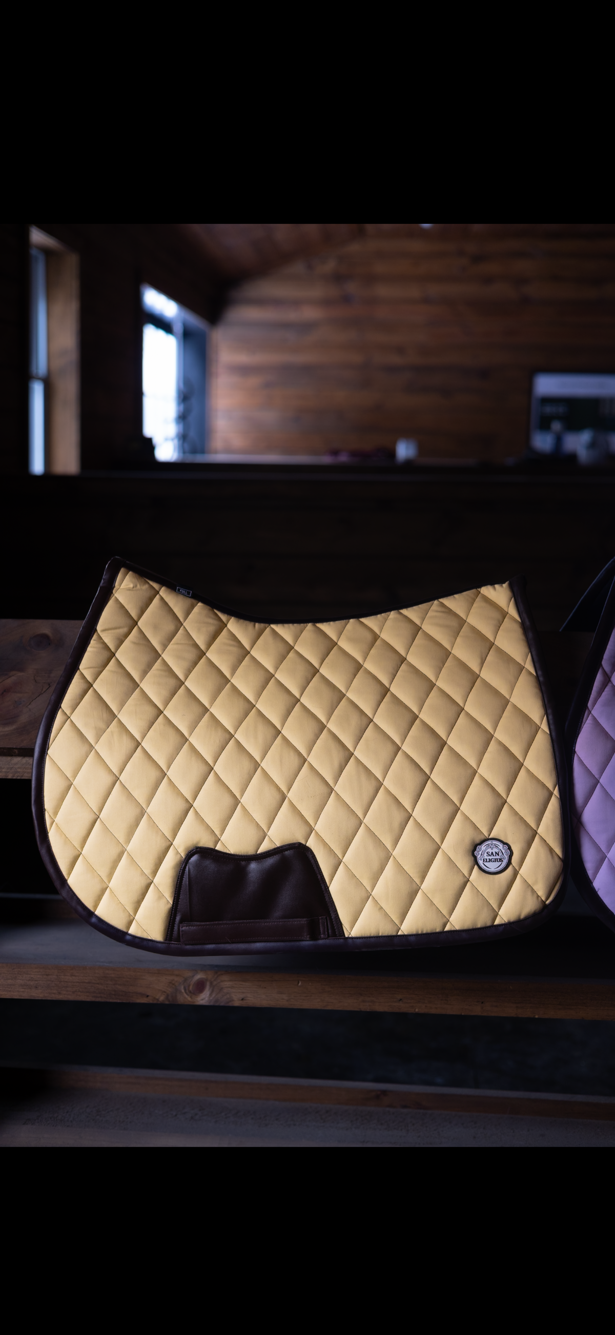 San Eligius yellow quilted jump saddle pad with brown leather piping, side profile view