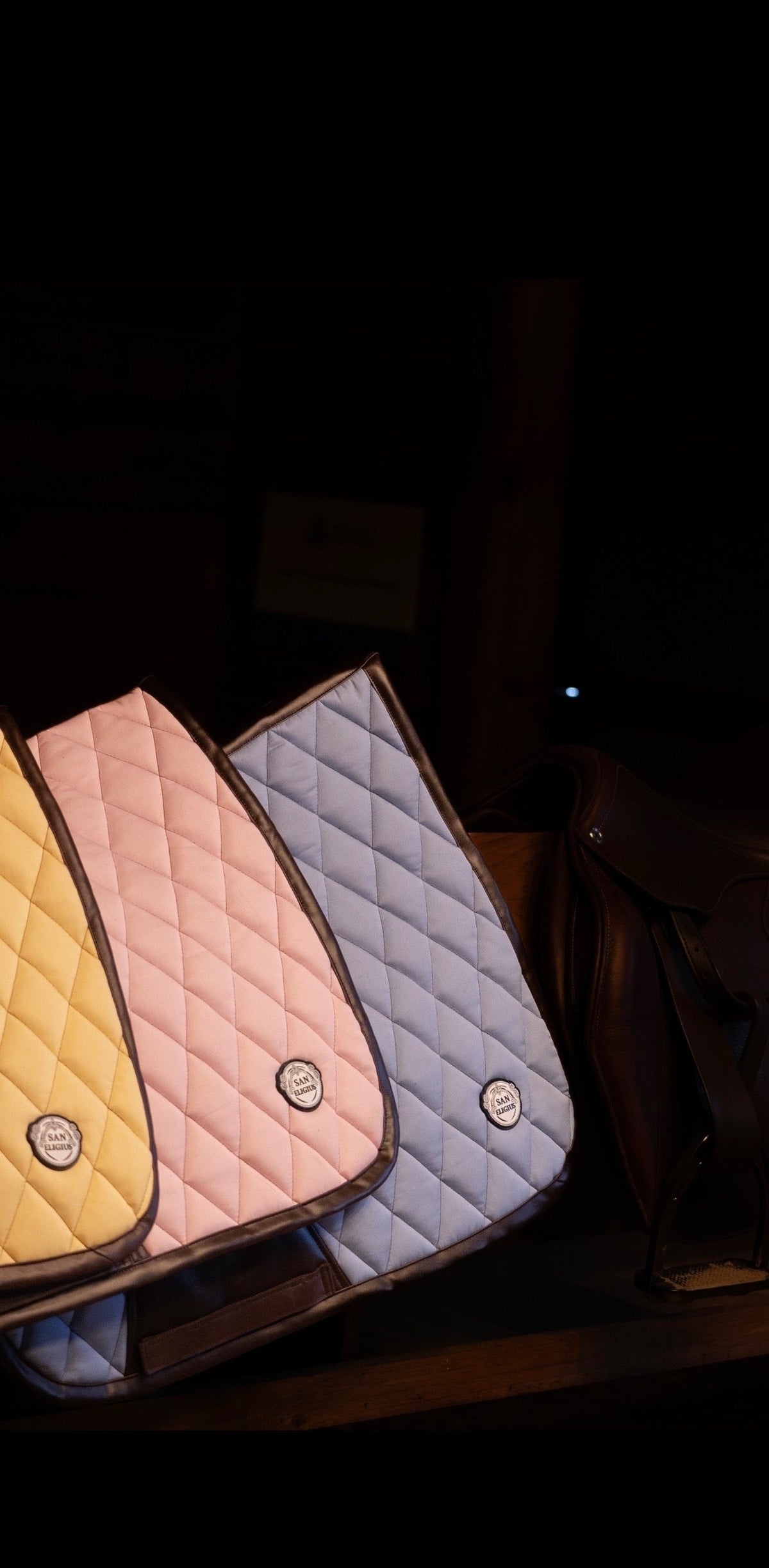 San Eligius light blue quilted jump saddle pad with brown leather piping, lifestyle shot on horse