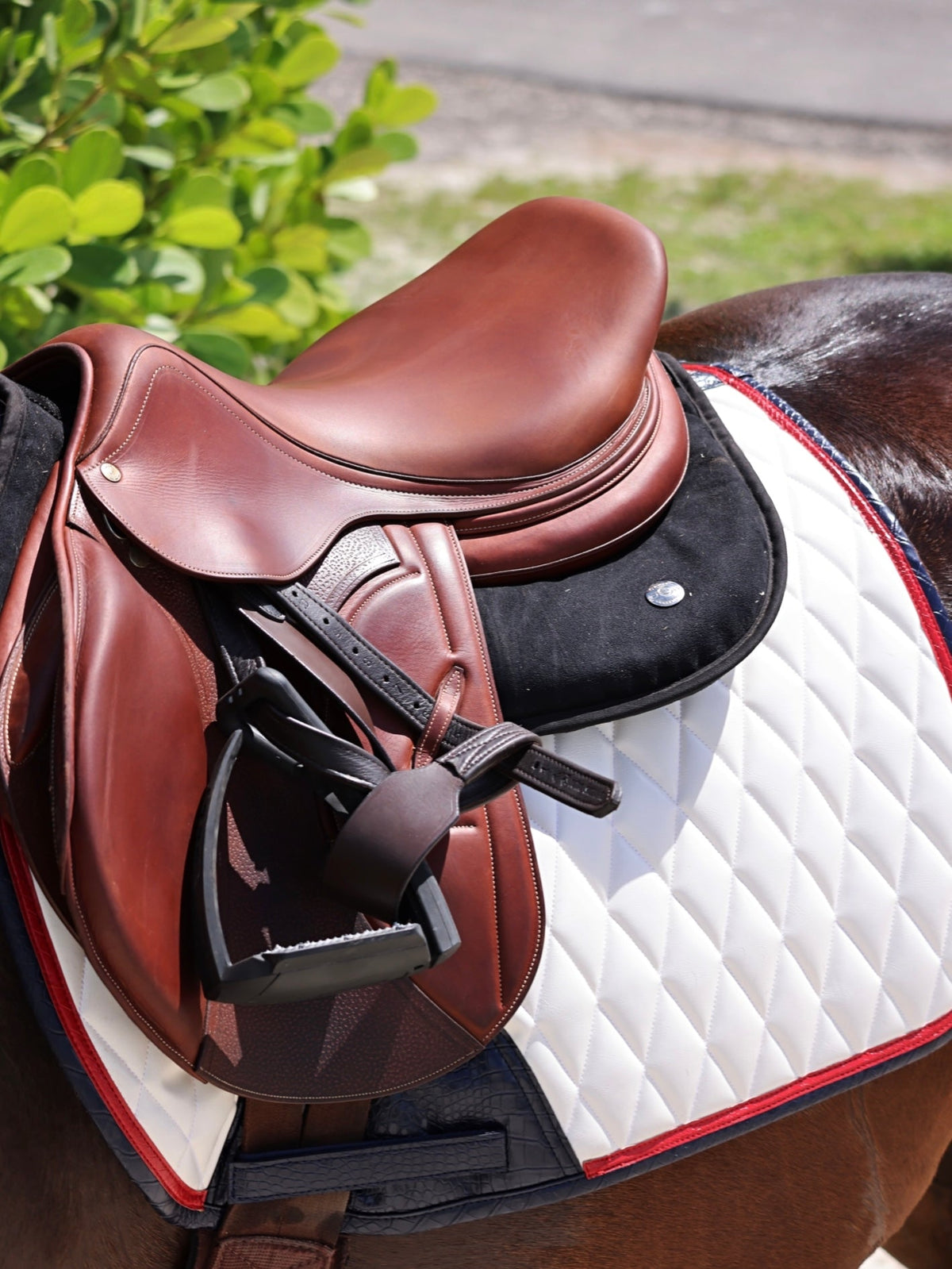 San Eligius white quilted jump saddle pad with red and navy crocodile piping