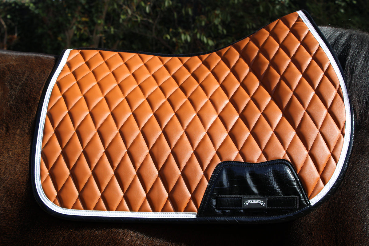 San Eligius cognac quilted jump saddle pad with white and black crocodile piping, quilted texture detail