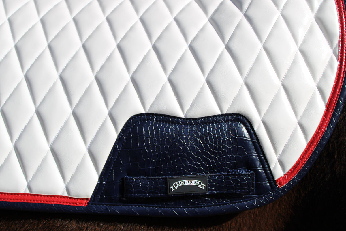 San Eligius white quilted jump saddle pad with red and navy crocodile piping, quilted texture detail