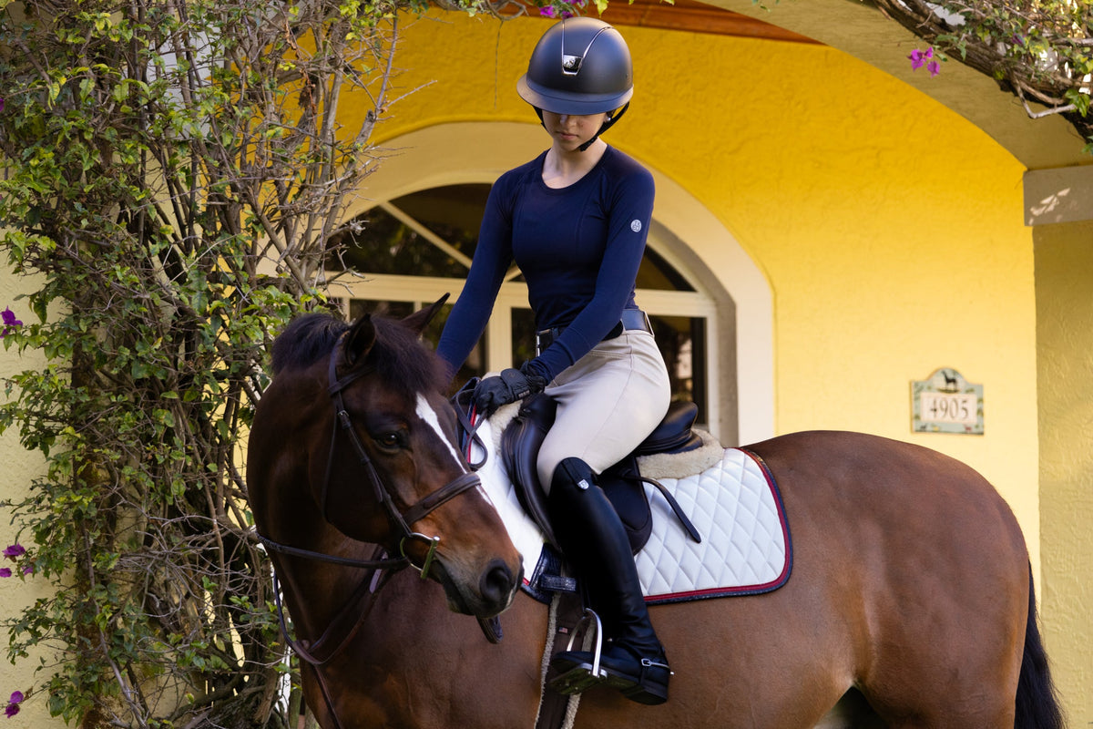 San Eligius white quilted jump saddle pad with red and navy crocodile piping, back view