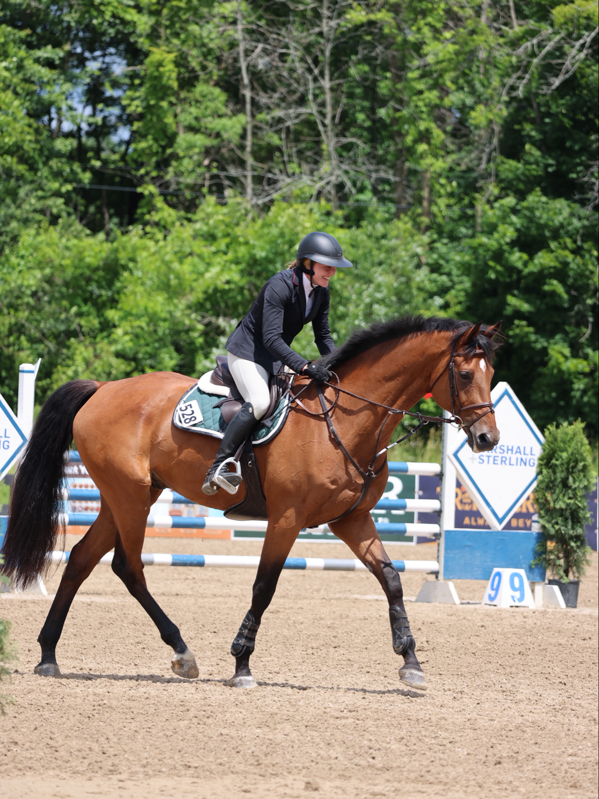 San Eligius green quilted jump saddle pad with white and black leather piping, detail of logo emblem
