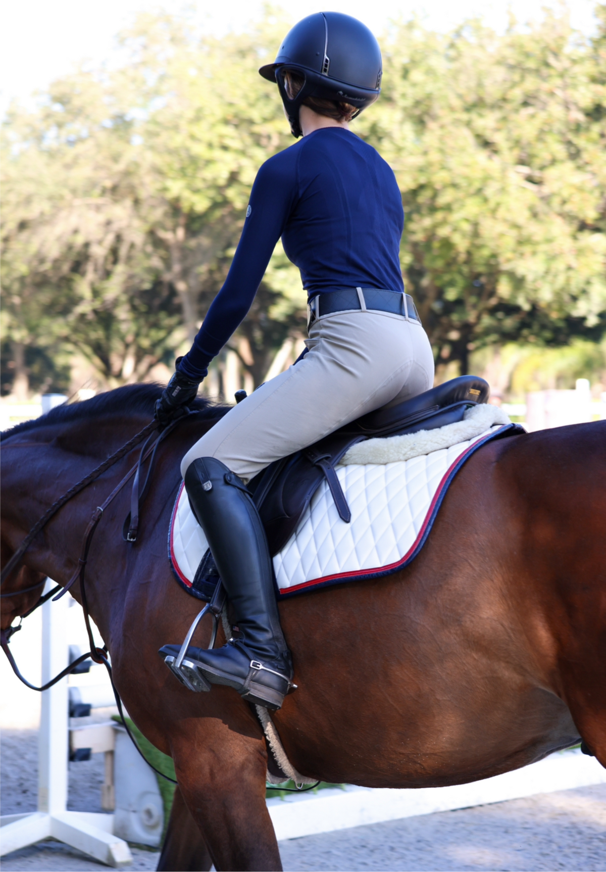San Eligius white quilted jump saddle pad with red and navy crocodile piping, flat lay front view