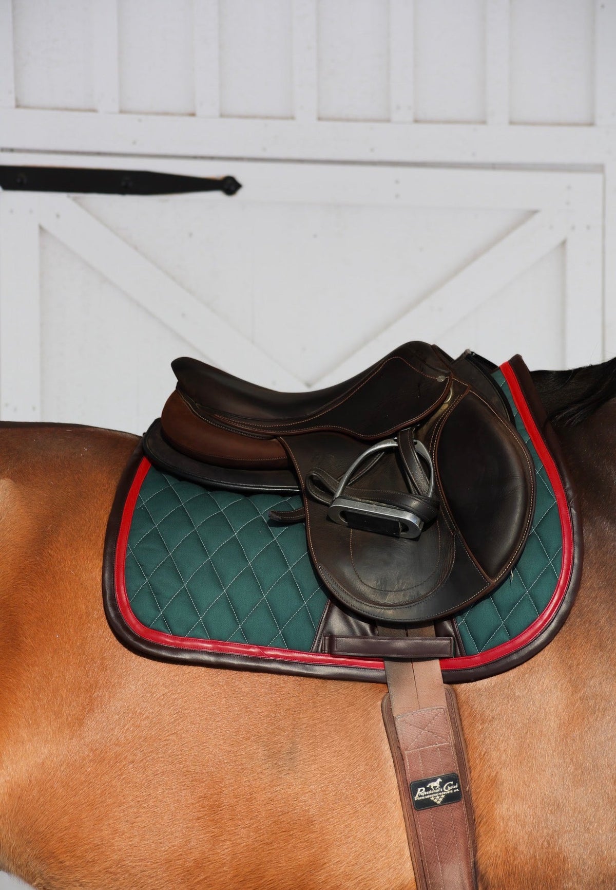 San Eligius green quilted jump saddle pad with red and brown leather piping