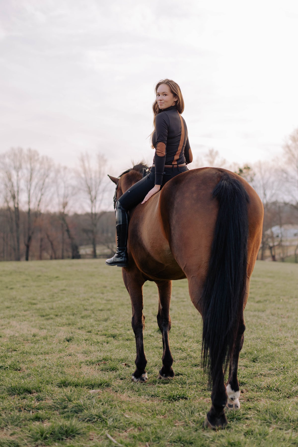 San Eligius black Blair riding top, turtleneck with elbow patches, back view showing stripe detail