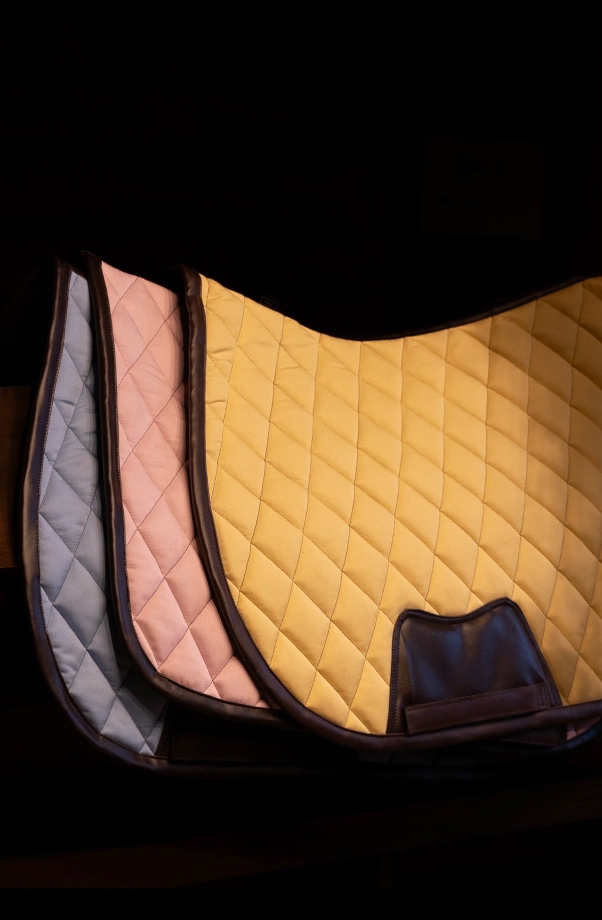 San Eligius light blue quilted jump saddle pad with brown leather piping, side profile view