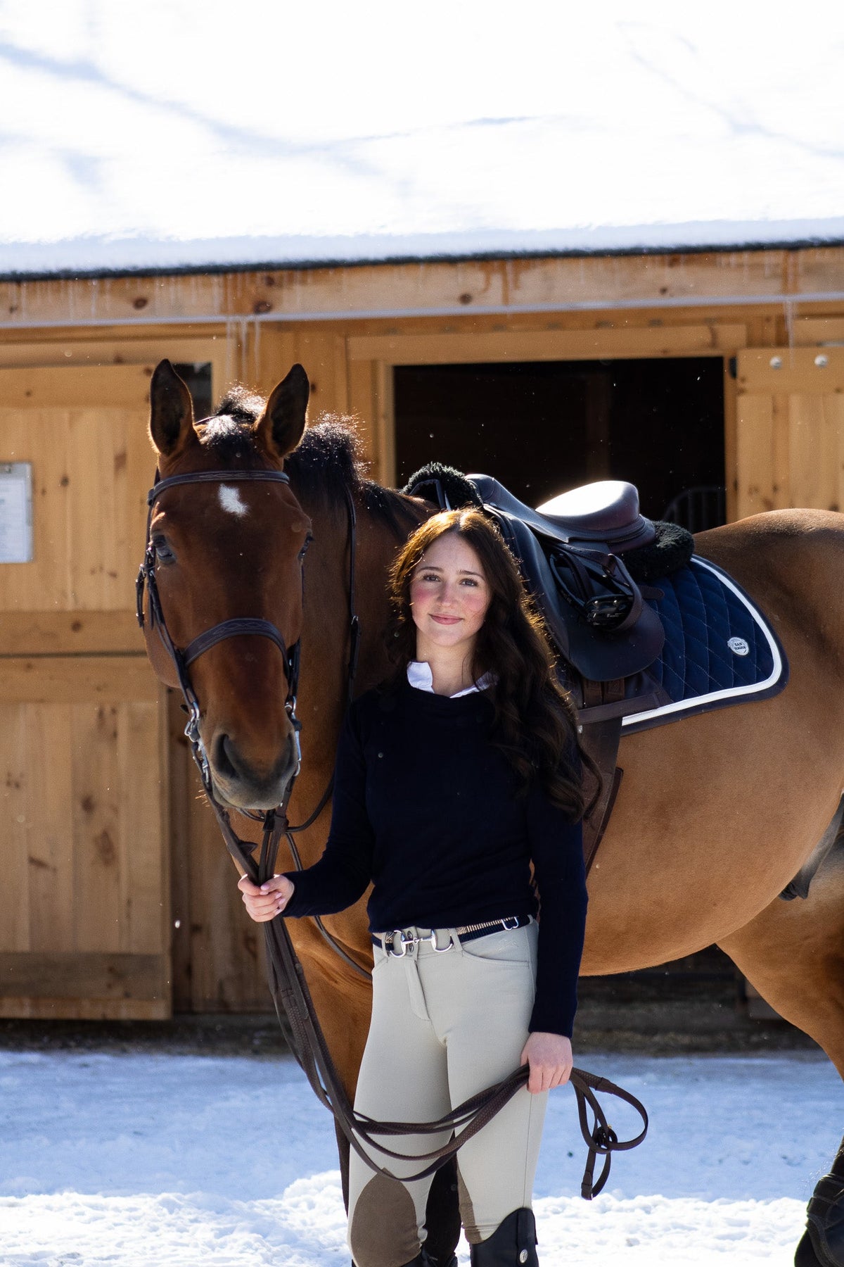 San Eligius navy quilted jump saddle pad with white and brown leather piping, flat lay front view