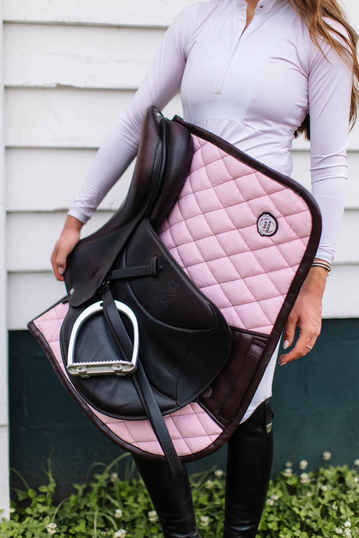 San Eligius pink quilted jump saddle pad with brown leather piping, detail of logo emblem