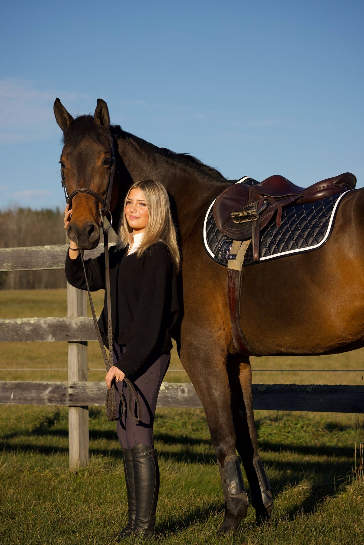 San Eligius black quilted jump saddle pad with white and black crocodile piping on horse under saddle