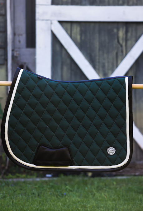 San Eligius green quilted jump saddle pad with white and black leather piping, lifestyle shot on horse